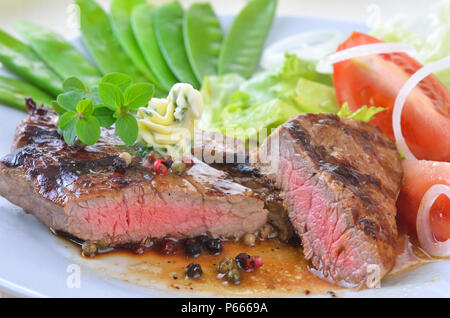 Medium gegrilltes Rindersteak mit Zuckererbsen und Salat Stockfoto