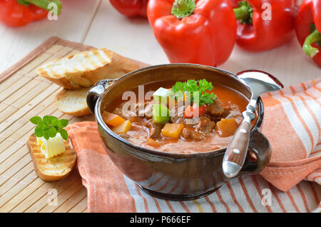 Typisch ungarische Gulaschsuppe mit Baguette Stockfoto