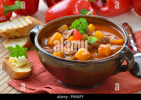 Typisch ungarische Gulaschsuppe mit Baguette Stockfoto