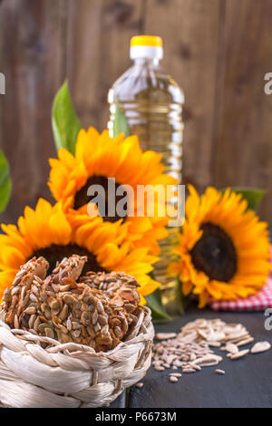 Öl dodsolnechnoe in eine große Flasche, ein Blumenstrauß aus Sonnenblumen Blumen, auf einem terned Hintergrund. Hausgemachte backen. Kekse mit Samen. Natürliches Produkt, rustikalen Stil. Platz kopieren Stockfoto