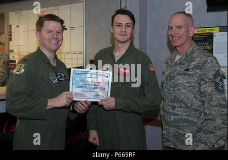 Colonel Christopher Maddox, 60th Operations, Commander und Chief Master Sgt. Alan Boling, command Chief, 60th AMW vom 21. Airlift Squadron gestoppt, Senior Airman Allyn Kenley mit dem 60 AMW Krieger der Woche, bei Travis AFB, Mar 8, 2016 zu präsentieren. (U.S. Air Force Foto von Heide Couch/Freigegeben) Stockfoto