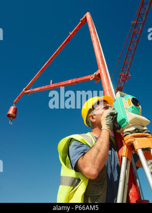 Mann mit Theodoliten auf Baustelle, niedrigen Winkel Stockfoto