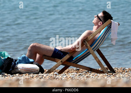 Ein Mann entspannt in das warme Wetter am Strand in Brighton, East Sussex, während die anhaltende Hitzewelle über dem Land. Stockfoto