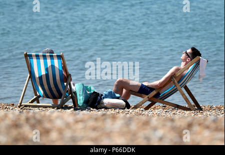 Ein paar genießen das warme Wetter am Strand in Brighton, East Sussex, während die anhaltende Hitzewelle über dem Land. Stockfoto