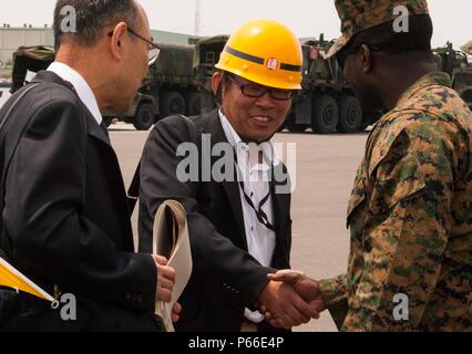 SENDAI, Japan - Kapitän Emmanuel Stimmen, der Offizier die Übung für die Artillerie Relocation Training Programm 16-1 arbeitet mit japanischen Einschiffung Fremdfirmen das Entladen der Artillerie in Sendai Port Überwachung am 9. Mai 2016. Stimmen ist mit 3.Bataillon, 12 Marine Regiment, 3rd Marine Division, III Marine Expeditionary Force in Camp Hansen, Okinawa, Japan beruht und sich von Washington, D.C. Stockfoto