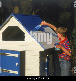 Junge Malerei selbstgebauten Holzhaus Stockfoto