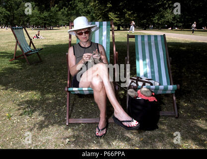 Tamera Doroucher aus Bethlehem, Pennsylvania, USA, Stricken Pantoffeln im Green Park, London. Briten werden die heißesten Temperaturen des Jahres für den vierten Tag in Folge diese Woche zu genießen, mit dem Mercury vorhergesagt steigen auf 32 C (105 F). Stockfoto