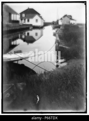Bungalows am Wasser in Oceanside. von Gertrude Käsebier 1852-1934, Fotograf. Datiert von 1905. Kleine Passage von Wasser durch Häuser und Docks flankiert. Stockfoto