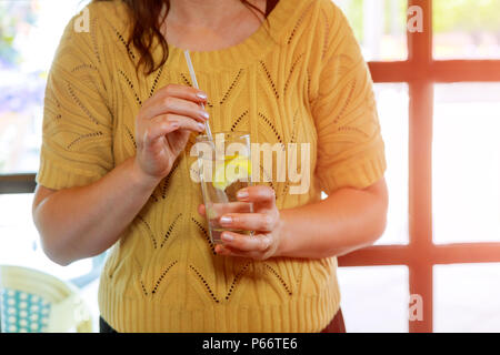 Womans hand mit einem kalten Glas Soda und Zitrone Stockfoto