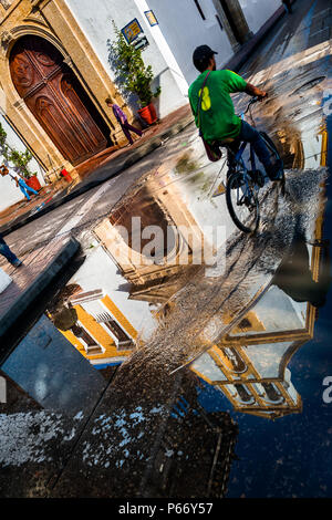 Ein kolumbianischer Radrennfahrer fährt mit dem Fahrrad vor Santo Toribio Kirche, in der kolonialen Stadt in Cartagena, Kolumbien. Stockfoto