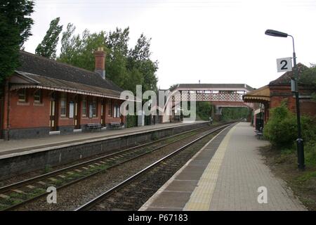 Blick von der Plattform des Bahnhofsgebäude in Wilmcote Station, Warwickshire, zeigt die Fuß-Brücke, Plattform Beleuchtung und Beschilderung. 2007 Stockfoto