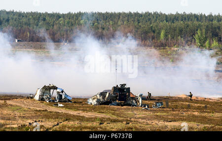 Am 12. Mai 2016 rückten Soldaten des 291. Infanterie-Bataillons während der Übung Hunter in Pabrade, Litauen, unter Rauchschutz in Richtung GTK-Boxer-Panzerflugzeuge vor. Soldaten trainierten auf Panzerabwehrwaffen wie Javelin, Spike und Carl Gustaf. Die Übung umfasste multinationale Streitkräfte, die Verbesserung der taktischen Koordination, der Panzermanöver und der Interoperabilität der verbündeten Einheiten. Stockfoto