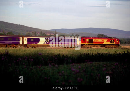 Ein EWS-Class 67 Lokomotive zieht ein scotrail Caledonian Sleeper Service in südlicher Richtung durch die wunderschöne schottische Landschaft im goldenen Abendlicht. Thi Stockfoto