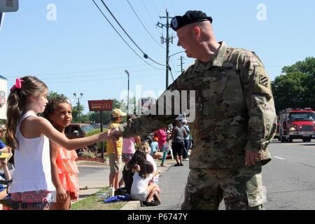 Chief Warrant Officer 3 Jared DeLaney, Kommandant der 3. Infanterie Division band, schüttelt die Hand eines Kindes während der glennville süße Zwiebel Festival Parade in Glennville, Ga 14. Mai 2016. Band Mitglieder Soldaten der Brigade 703rd Support Battalion, 2nd Infantry Brigade Combat Team, 3rd Infantry Division für die Veranstaltung. (U.S. Armee Foto von SPC. Corey Meister/Freigegeben) Stockfoto