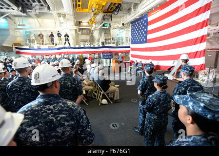 160520-N-YZ 252-112 BADEWANNE, Maine (20. Mai 2016) Kapitän James Downey, Program Manager für DDG 1000, spricht mit montierten Crew Mitglieder und Gäste im Hangar Bay an Bord der Zukunft geführte Anti-raketen-Zerstörer USS Zumwalt (DDG 1000) während der Übertragung des Eigentums Zeremonie. Die US-Marine akzeptiert Lieferung der DDG 1000, die Zukunft USS Zumwalt Zerstörer 20. Mai 2016. Nach einer Crew Zertifizierung Zeitraum und Oktober Inbetriebnahme Zeremonie in Baltimore, Zumwalt wird Transit zu seinen Heimathafen in San Diego für einen Post Lieferung Verfügbarkeit und Mission Systeme Aktivierung. DDG 1000 ist der Leitung Schiff der Zumwalt Stockfoto