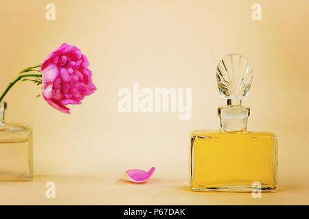 Flasche Parfüm, und die Blume, die verblasst und fällt. Stockfoto