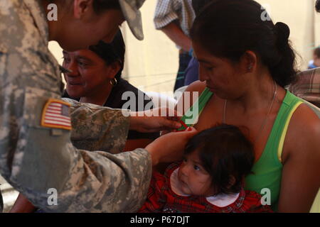 Us-Armee SPC. Jessie Castillo, mit der 413 zivilen Angelegenheiten, Tag Bänder der Pin Mutter auf Patienten während der medizinischen Readiness Training übung in San Padro, Guatemala, 10. Mai 2016. Task Force Red Wolf und Armee nach Süden führt Humanitäre Zivile Hilfe Ausbildung taktischer Ebene Bauprojekte und medizinische Bereitschaft Übungen medizinische Zugang und den Bau von Schulen in Guatemala mit der guatemaltekischen Regierung und nicht-staatlichen Stellen von 05 Mär 16 bis 18 Apr 16 Um die Mission die Bereitschaft der US-Streitkräfte zu verbessern und einen nachhaltigen Nutzen für die Menschen zu gehören Stockfoto