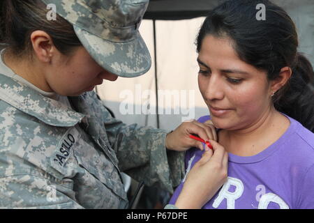 Us-Armee SPC. Jessie Castillo, mit der 413 zivilen Angelegenheiten, Tag Bänder der Pin Mutter auf Patienten während der medizinischen Readiness Training übung in San Padro, Guatemala, 10. Mai 2016. Task Force Red Wolf und Armee nach Süden führt Humanitäre Zivile Hilfe Ausbildung taktischer Ebene Bauprojekte und medizinische Bereitschaft Übungen medizinische Zugang und den Bau von Schulen in Guatemala mit der guatemaltekischen Regierung und nicht-staatlichen Stellen von 05 Mär 16 bis 18 Apr 16 Um die Mission die Bereitschaft der US-Streitkräfte zu verbessern und einen nachhaltigen Nutzen für die Menschen zu gehören Stockfoto