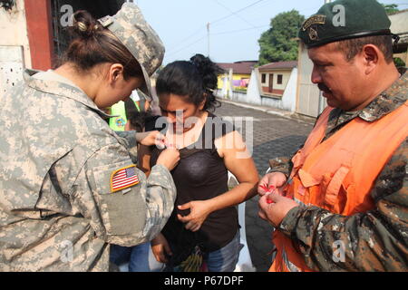 Us-Armee SPC. Jessie Castillo, mit der 413 zivilen Angelegenheiten, Tag Bänder der Pin Mutter auf Patienten während der medizinischen Readiness Training übung in San Padro, Guatemala, 10. Mai 2016. Task Force Red Wolf und Armee nach Süden führt Humanitäre Zivile Hilfe Ausbildung taktischer Ebene Bauprojekte und medizinische Bereitschaft Übungen medizinische Zugang und den Bau von Schulen in Guatemala mit der guatemaltekischen Regierung und nicht-staatlichen Stellen von 05 Mär 16 bis 18 Apr 16 Um die Mission die Bereitschaft der US-Streitkräfte zu verbessern und einen nachhaltigen Nutzen für die Menschen zu gehören Stockfoto