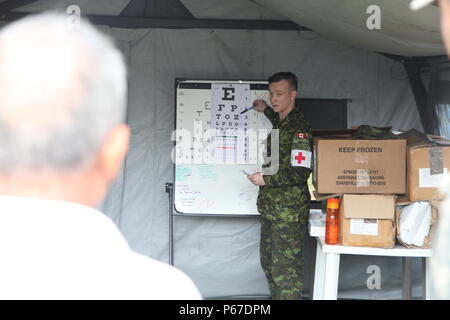 Kanadische Streitkräfte Cpl. Matthews Todd mit 23 Kanadische Streitkräfte Gesundheitswesen wertet eine guatemaltekische Patient mit einem Auge Diagramm in der optometrie Zelt bei San Padro, Guatemala, 10. Mai 2016. Task Force Red Wolf und Armee nach Süden führt Humanitäre Zivile Hilfe Ausbildung auf taktischer Ebene Bauprojekte und medizinische Bereitschaft Übungen medizinische Zugang und den Bau von Schulen in Guatemala mit der guatemaltekischen Regierung und nicht-staatlichen Stellen von 05 Mär 16 bis 18 Apr 16 Um die Mission die Bereitschaft der US-Streitkräfte zu verbessern und einen nachhaltigen Nutzen für die pe zu liefern. Stockfoto