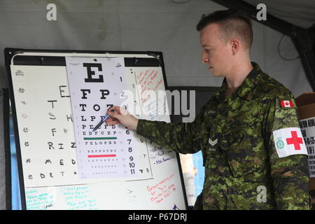 Kanadische Streitkräfte Cpl. Matthews Todd mit 23 Kanadische Streitkräfte Gesundheitswesen wertet eine guatemaltekische Patient mit einem Auge Diagramm in der optometrie Zelt bei San Padro, Guatemala, 10. Mai 2016. Task Force Red Wolf und Armee nach Süden führt Humanitäre Zivile Hilfe Ausbildung auf taktischer Ebene Bauprojekte und medizinische Bereitschaft Übungen medizinische Zugang und den Bau von Schulen in Guatemala mit der guatemaltekischen Regierung und nicht-staatlichen Stellen von 05 Mär 16 bis 18 Apr 16 Um die Mission die Bereitschaft der US-Streitkräfte zu verbessern und einen nachhaltigen Nutzen für die pe zu liefern. Stockfoto