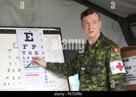 Kanadische Streitkräfte Cpl. Matthews Todd mit 23 Kanadische Streitkräfte Gesundheitswesen wertet eine guatemaltekische Patient mit einem Auge Diagramm in der optometrie Zelt bei San Padro, Guatemala, 10. Mai 2016. Task Force Red Wolf und Armee nach Süden führt Humanitäre Zivile Hilfe Ausbildung auf taktischer Ebene Bauprojekte und medizinische Bereitschaft Übungen medizinische Zugang und den Bau von Schulen in Guatemala mit der guatemaltekischen Regierung und nicht-staatlichen Stellen von 05 Mär 16 bis 18 Apr 16 Um die Mission die Bereitschaft der US-Streitkräfte zu verbessern und einen nachhaltigen Nutzen für die pe zu liefern. Stockfoto