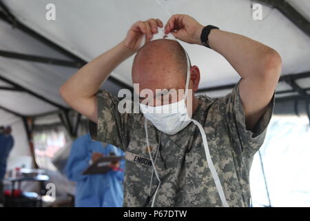 Us-Armee Maj. John verleihen mit dem 185 Dental Gmbh, seine chirurgischen Maske für einen Patienten während einer medizinischen Bereitschaft Übung in San Padro, Guatemala, 10. Mai 2016 vorzubereiten. Task Force Red Wolf und Armee nach Süden führt Humanitäre Zivile Hilfe Ausbildung taktischer Ebene Bauprojekte und medizinische Bereitschaft Übungen medizinische Zugang und den Bau von Schulen in Guatemala mit der guatemaltekischen Regierung und nicht-staatlichen Stellen von 05 Mär 16 bis 18 Apr 16 Um die Mission die Bereitschaft der US-Streitkräfte zu verbessern und einen nachhaltigen Nutzen für die Menschen in Guatemal aufzunehmen Stockfoto