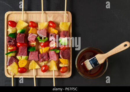 Rohes Rindfleisch Grill mit Gemüse auf Holz Platte und Barbecue Sauce Stockfoto