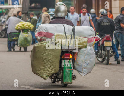 Hanoi, Vietnam - da Autos teuer sind und der Verkehr verrückt, in Vietnam Motorroller gebrauchte Ware an Stelle des Autos zu transportieren, oft überlastet sind Stockfoto