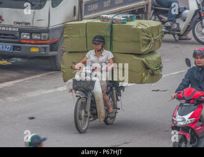 Hanoi, Vietnam - da Autos teuer sind und der Verkehr verrückt, in Vietnam Motorroller gebrauchte Ware an Stelle des Autos zu transportieren, oft überlastet sind Stockfoto