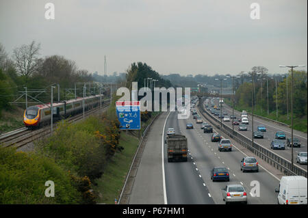 Die Autobahn M1 in Watford Gap als Norden gebunden Virgin Trains Pendolino auf der West Coast Main Line Rennen der Verkehr auf eine Reise in den Norden. April 20. Stockfoto