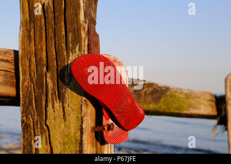 Rote flip flops Hängen auf hölzernen Pfosten Stockfoto