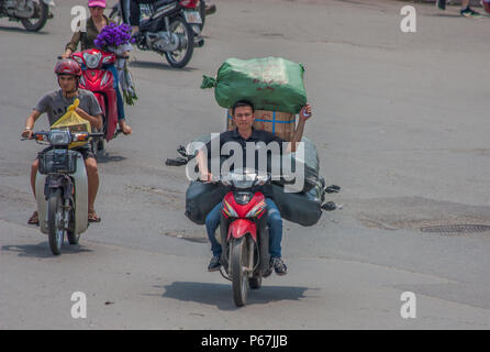 Hanoi, Vietnam - da Autos teuer sind und der Verkehr verrückt, in Vietnam Motorroller gebrauchte Ware an Stelle des Autos zu transportieren, oft überlastet sind Stockfoto