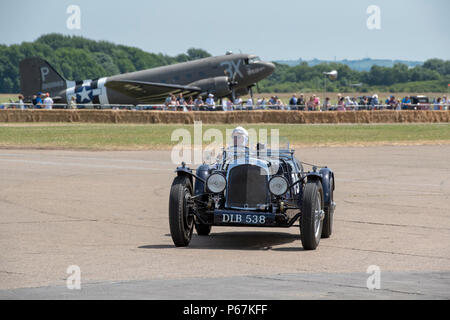 Jahrgang 1936 Aston Martin vor einem Douglas Dakota Flugzeuge im Bicester Schwungrad Festival, Bicester Heritage Center, Oxfordshire, England Stockfoto