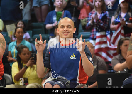 Ein Navy Fire Controlman unterschreibt seine Familie in den Tribünen, nachdem das US-Team am 12. Mai 2016 während der Invictus Games die Goldmedaille im Rollstuhlbasketball in Orlando, Florida, gewonnen hat. Dieser internationale adaptive Sportwettbewerb unterstützt verwundete, kranke und verletzte Servicemitglieder und Veteranen durch Förderung von Rehabilitation, Teamarbeit, sportlichem Können und Moral. Stockfoto