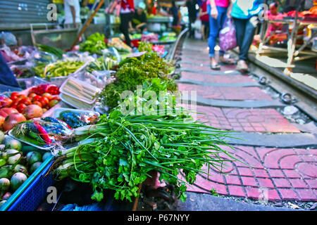 Verkauf von Speisen auf der Maeklong Railway Markt in Thailand. Stockfoto