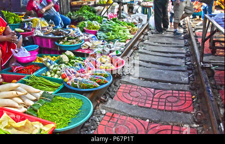 Verkauf von Speisen auf der Maeklong Railway Markt in Thailand. Stockfoto