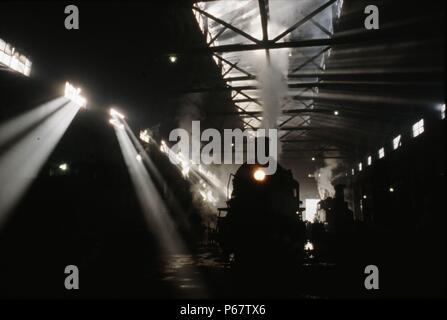 Sonnenlicht Rauch und Schatten. Eine chinesische SY Klasse industrielle Mikado 2-8-2 befindet sich inmitten der smokey Trübsinn in Anshan Iron & Steel Works Schuppen. Einige 1750 aus Stockfoto