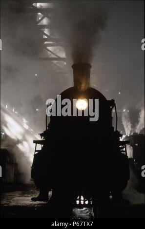 Sonnenlicht Rauch und Schatten. Eine chinesische SY Klasse industrielle Mikado 2-8-2 befindet sich inmitten der smokey Trübsinn in Anshan Iron & Steel Works Schuppen. Einige 1750 aus Stockfoto