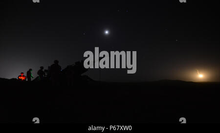 Studenten an der Field Artillery Basic Offiziere Führung Kurs Nacht Brände mit einem M77 A2 Howitzer bei Fort Sill, Oklahoma, 11. Mai 2016. Studenten im Kurs erlernen Sie, wie man die Beleuchtung runden zu nutzen, um Ziele in der Dunkelheit zu finden. Stockfoto