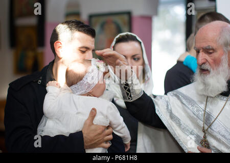 Belarus, Gomel, am 25. März. 2018. Die Prudhkovsky Kirche. Der Priester führt die Taufe des Kindes. Zeremonie der Annahme des Glaubens Stockfoto