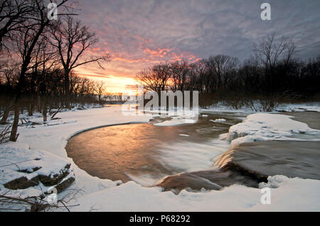 Das kühle Wasser der Prairie Creek fließt über einen Wasserfall in der Sonne an einem Wintertag. Des Plaines Conservation Area, County, Illinois, USA. Stockfoto