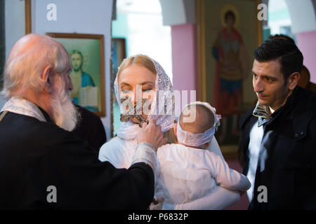 Belarus, Gomel, am 25. März. 2018. Die Prudhkovsky Kirche. Die Taufe eines Kindes. Während die Taufe eines Kindes, Eine Frau küsst ein Kreuz Stockfoto