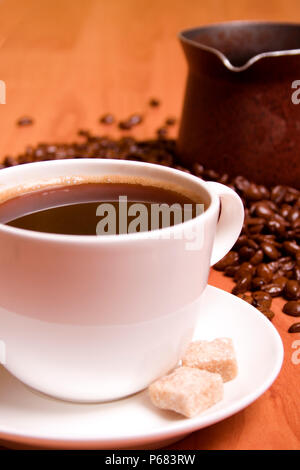 Tasse Kaffee, Caffee, Zucker und Bohnen auf hölzernen Tisch Stockfoto