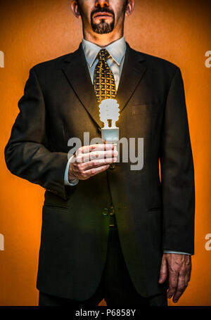 Ein Geschäftsmann mit einer beleuchteten CFL-Lampe. Stockfoto