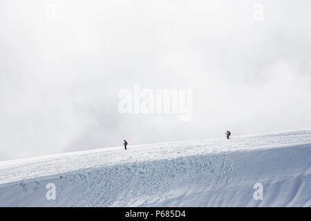 Zwei Wanderer/Kletterer Abstieg vom Gletscher und Schneefelder des Mount Rainier als niedrige Wolken steigen und um sie herum fallen, Mount Rainier National Stockfoto