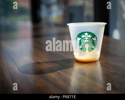 Mini Kunststoff Verkostung mit leeren Tasse Kaffee. Kostenlose Geschmack Kaffee für Kunden auf hölzernen Tisch in der Starbucks Coffee Shop. Stockfoto