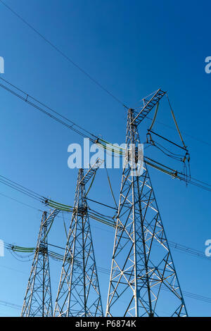 Drei power line Masten vor blauem Himmel Hintergrund Stockfoto