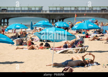 2018 Hitzewelle, die Menschen beim Sonnenbaden am Strand sonnenbaden bei dem heißen Wetter in der Nähe der Pier in Boscombe, Bournemouth, Dorset, Großbritannien Stockfoto