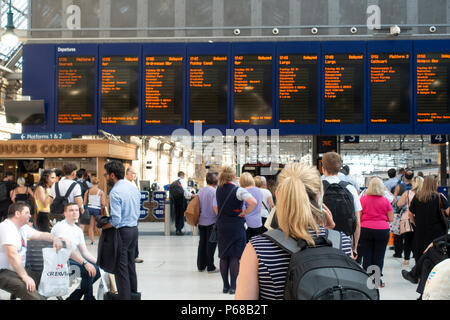 Glasgow, Schottland, Großbritannien. 28. Juni 2018. Passagiere auf dem Zusammentreffen von Glasgow Central Station warten auf Nachricht von Abflug, nach dem die meisten frühen Abend Hauptverkehrszeit Züge verzögert worden sind oder durch Signalisierung Ausfälle oder die Einführung von Geschwindigkeitsbeschränkungen aufgehoben. Stockfoto